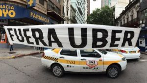 Taxistas protestando con cartel de Fuera Uber en Uruguay